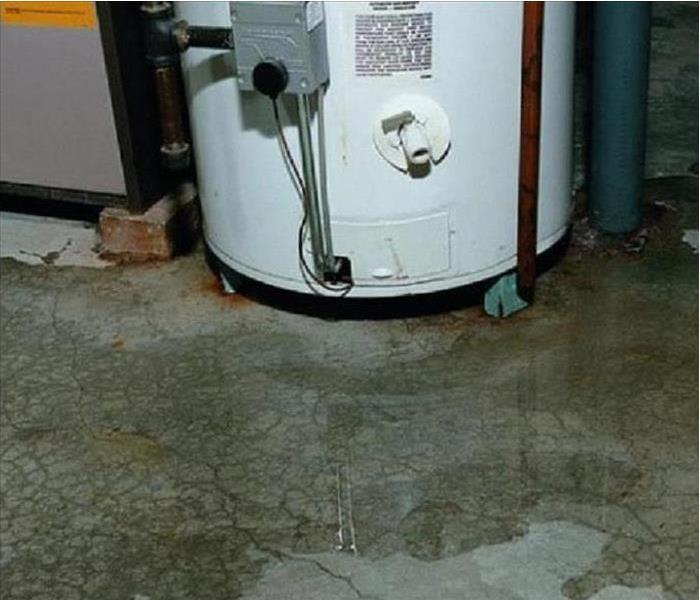 white water heater surrounded by water on concrete floor